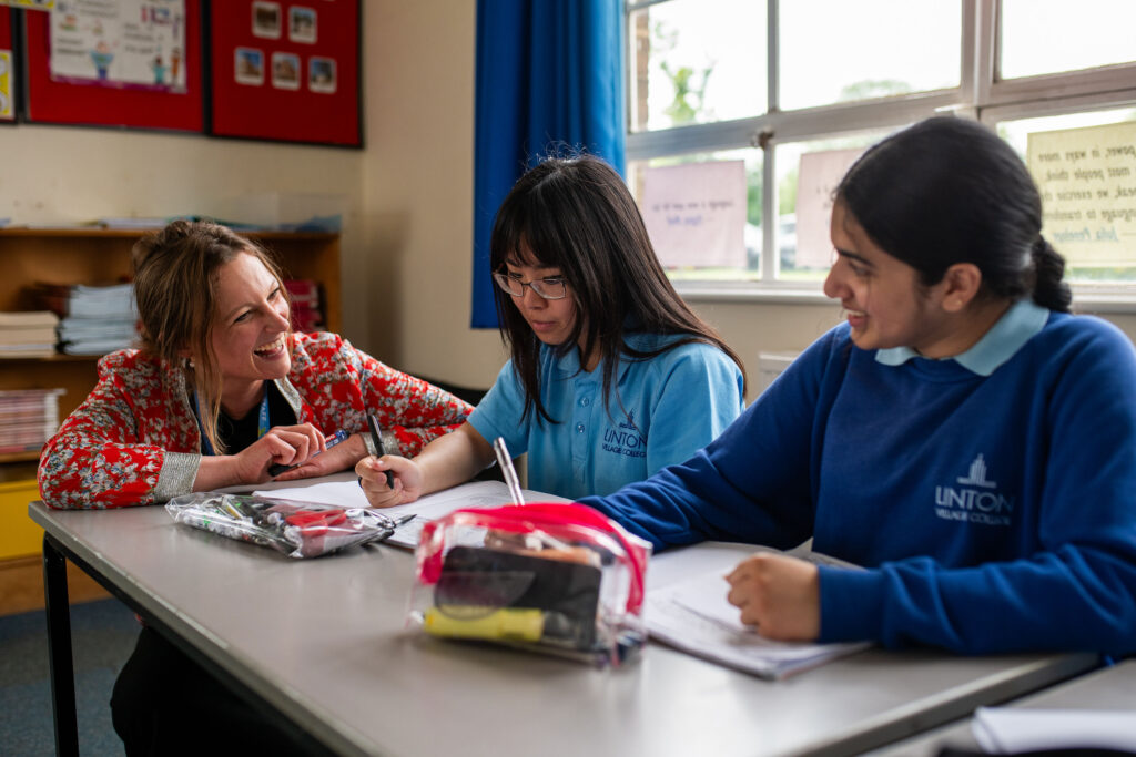 A teacher discussing work with two students