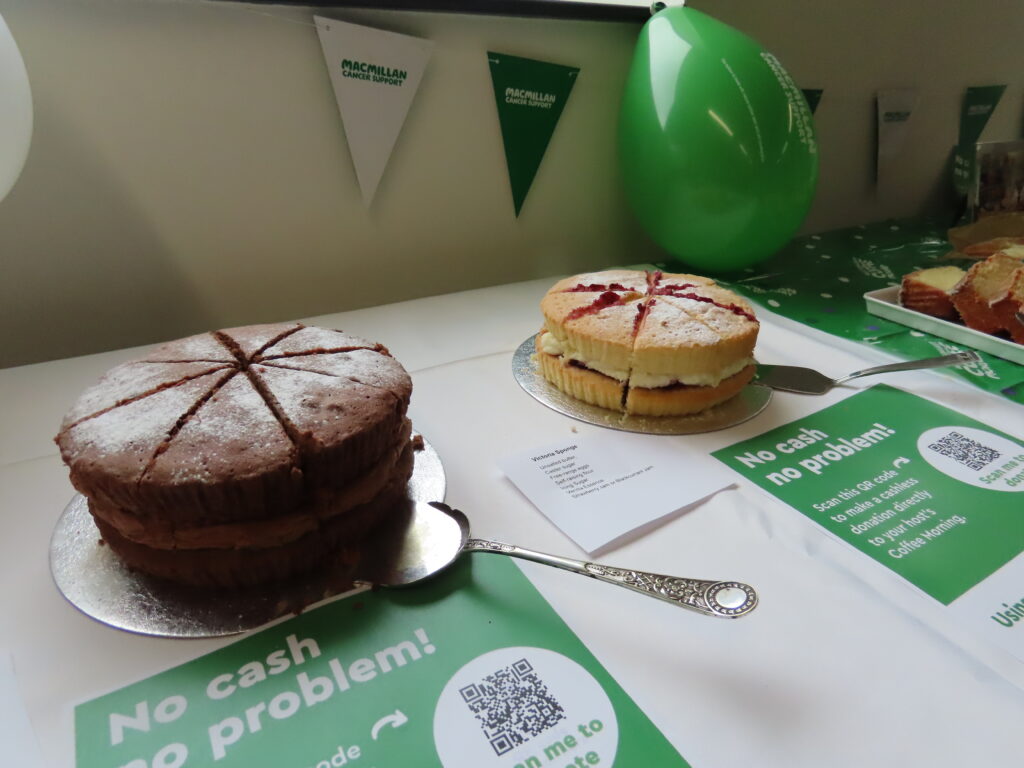 Two sponge cakes, one Chocolate and one a Victoria sponge, on a table.