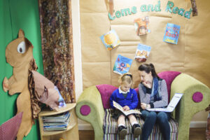 A child sitting with a teacher reading