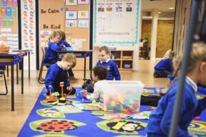 Three children playing on a mat on the floor