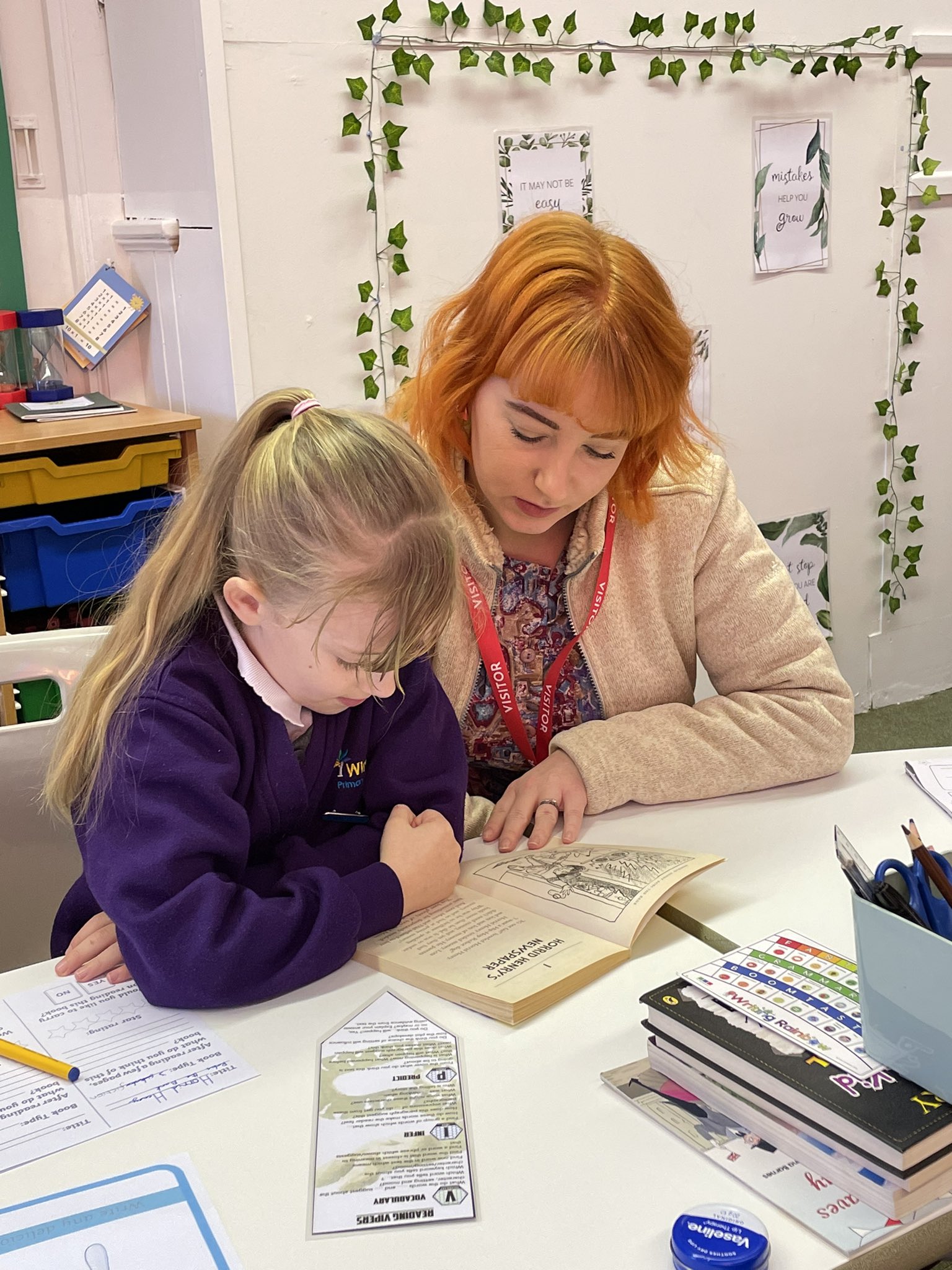 A child and teacher reading a book