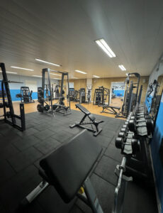 An indoor gym with gym equipment including a cycling machine and running machines