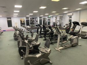 An indoor gym with gym equipment including a cycling machine and running machines