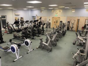 An indoor gym with gym equipment including a cycling machine and running machines