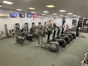 An indoor gym with gym equipment including a cycling machine and running machines