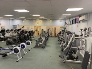 An indoor gym with gym equipment including a cycling machine and running machines