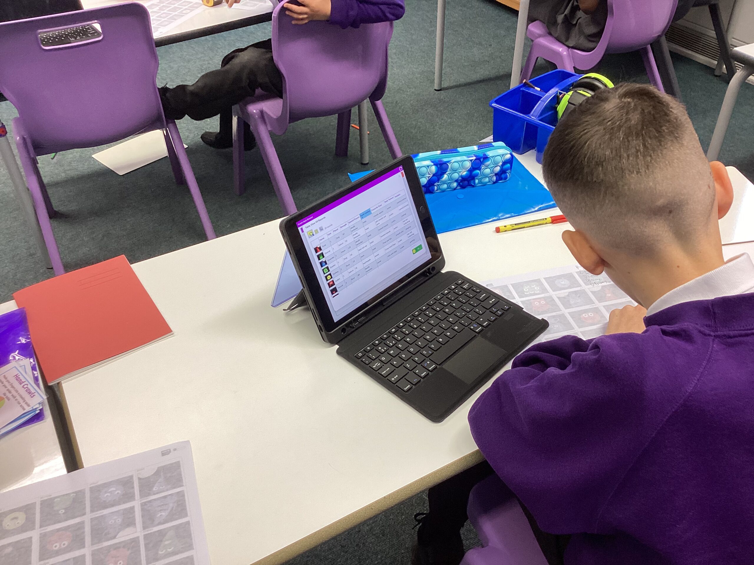 A pupil iis sitting at a desk with an iPad.