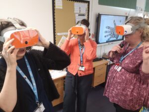 Three adults are standing wearing VR headsets.