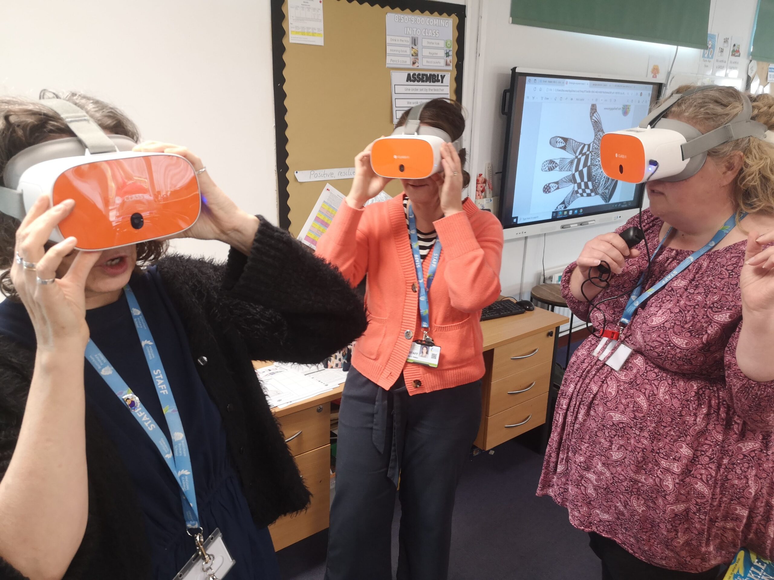 Three adults are standing wearing VR headsets.