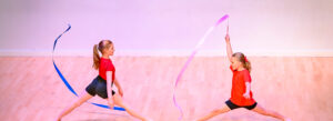 Two children dancing with pink and blue ribbons