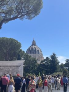 A building with a dome behind some trees.