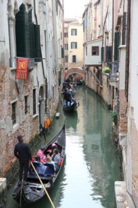 Gondolas in a narrow canal between buildings