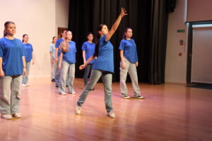 Students performing a dance routine on stage