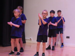 A group of children clapping during a dance routine