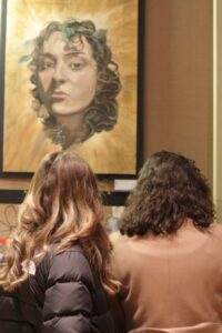 Two people looking at a self portrait.